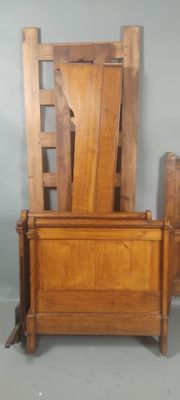 un lit avec une tête et un pied de lit en bois, à côté d'un coffre