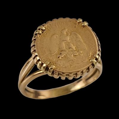 a close up of a gold ring with a coin on it
