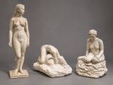three sculptures of a woman sitting on a rock next to another statue