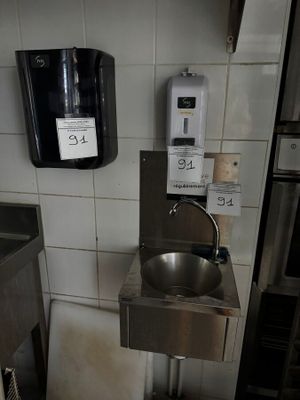 une photo de toilettes publiques avec un lavabo et des toilettes