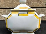 a yellow and white teapot on a black table