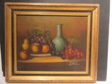 une photo d'un tableau représentant des fruits et un vase posés sur une table