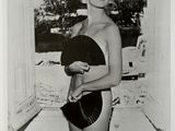 photographie en noir et blanc d'une femme en maillot de bain tenant un éventail