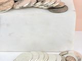 a pile of coins sitting on top of a white box