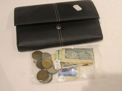 un sac à main noir contenant de la monnaie et des pièces, posé sur la table