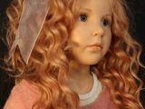 a doll that is wearing a pink sweater and a bow