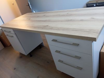 un bureau blanc muni de tiroirs, dans une pièce
