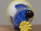 a blue and yellow vase with a sun on top of it