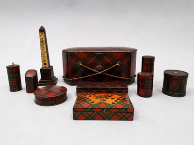une boîte à carreaux rouges et verts et d'autres objets posés sur une surface blanche