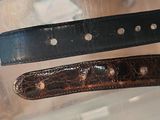 two belts that are sitting on top of a table