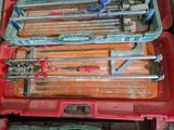 beaucoup d'outils dans une mallette rouge posée par terre