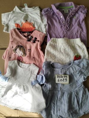 a lot of baby clothes that are in a cardboard box
