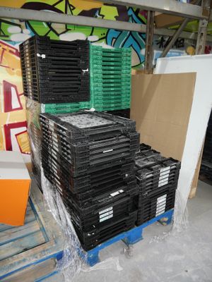 de nombreuses piles de CD empilées sur une palette dans un entrepôt