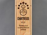 une boîte en bois sur laquelle est collée une étiquette verte portant l'inscription « Chartreuse »