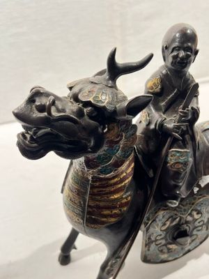 une statue représentant un homme chevauchant un taureau, avec un bouclier sur le dos