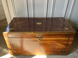 an antique wooden trunk with brass hardware on the top