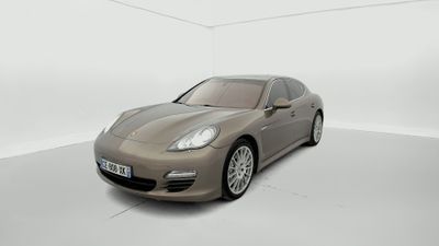 une Porsche Panamera marron garée dans une pièce blanche