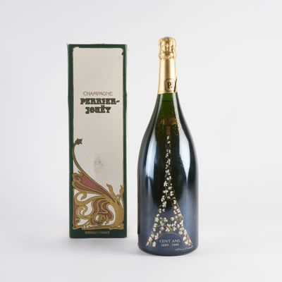 une bouteille de champagne posée à côté d'une boîte sur une surface blanche