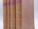 three old books are stacked on top of each other on a white surface