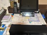 a laptop computer sitting on top of a desk covered in papers