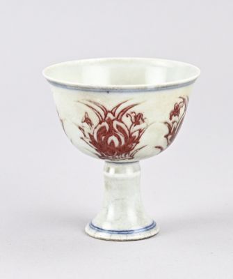 une tasse blanche et rouge posée sur une table