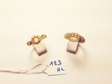 two gold rings with a tag on a white surface