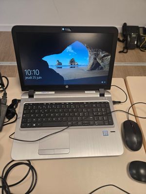 un ordinateur portable posé sur un bureau, avec une souris à côté