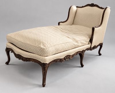 une chaise longue ancienne avec assise rembourrée et repose-pieds