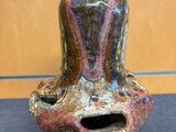 un vase coloré percé d'un trou, posé sur une table