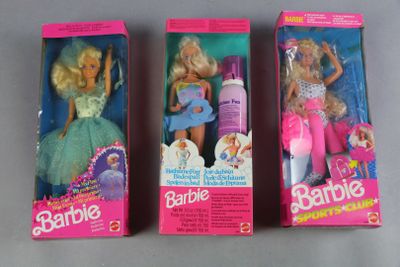 three barbie dolls are in their boxes on a gray surface