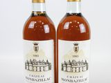 deux bouteilles de vin posées l'une à côté de l'autre sur une surface blanche