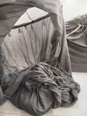 un lit recouvert d'un couvre-lit gris dans une chambre