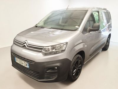 La camionnette argentée est garée dans la pièce blanche d'un immeuble.