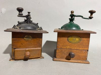 pair of antique coffee grinders on wooden bases with brass knobs