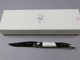 a black and white knife sitting next to a white box