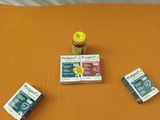 un lit recouvert d'un drap orange, sur lequel sont posés quelques livres