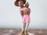a figurine of a woman holding a child on a marble table