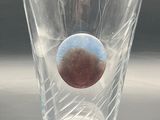 a clear glass with a brown eye inside of it