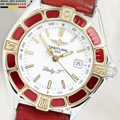 a close up of a red and white watch on a white surface