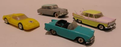 plusieurs petites voitures sont alignées sur une surface blanche