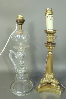 three glass and brass candlesticks and a glass vase on a table