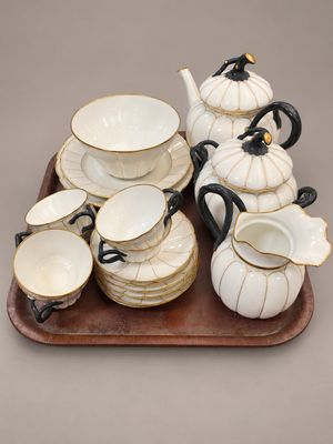 un plateau sur lequel se trouvent une théière, des tasses et des soucoupes