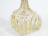 a clear glass bottle with gold trimmings on it