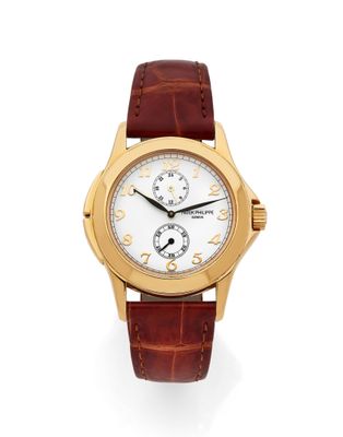 une montre-bracelet en or jaune, avec un cadran blanc et un bracelet en cuir marron