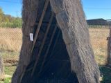 une petite cabane en foin au milieu d'un champ