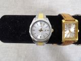 two watches that are on display on a black stand