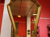 un miroir accroché au mur rouge d'une pièce