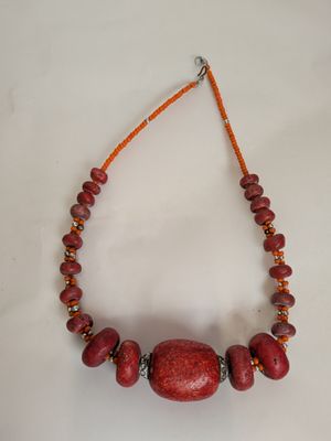 necklace made of red coral beads and orange glass beads on a string