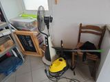 a small room with a fan and a chair in it
