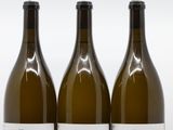 trois bouteilles de vin posées les unes à côté des autres sur une surface blanche